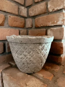 A textured pot on bricks