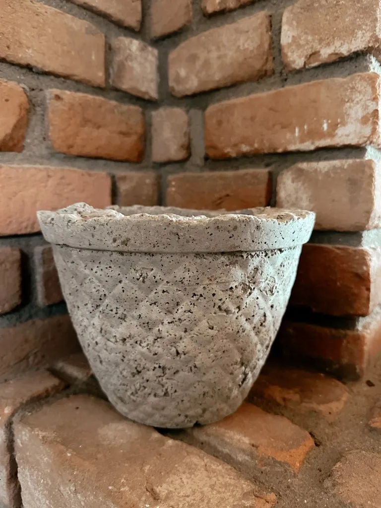 A textured pot on bricks